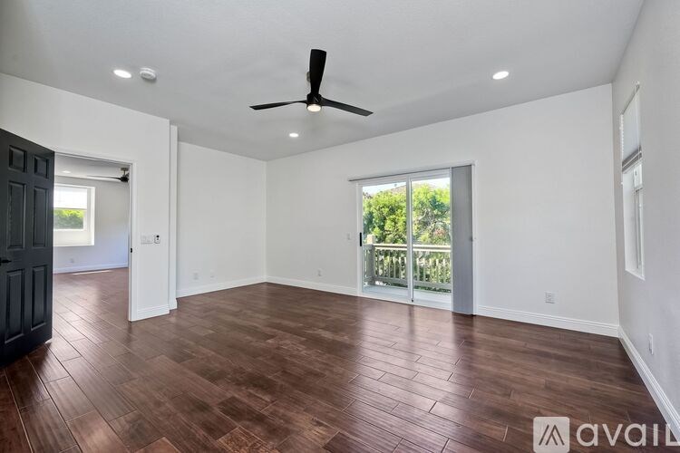 A room with wooden flooring and a ceiling fan.