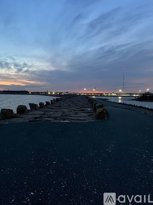 A long pier extends into a body of water under a twilight sky.