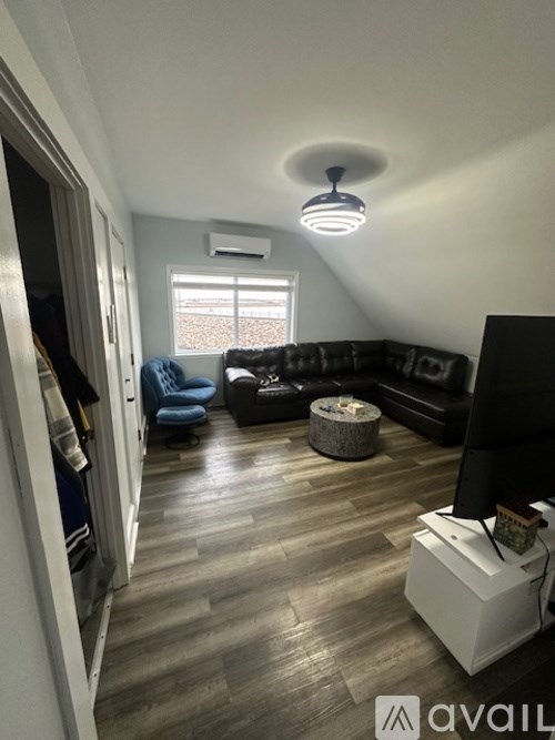 A living room with a black couch and a television.