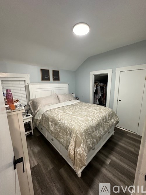 A bedroom with a bed, nightstand, and a closet.