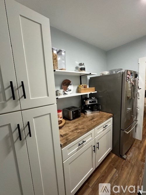A kitchen with white cabinets and a wooden countertop.