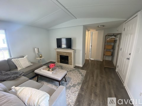 A living room with a grey couch and a fireplace.