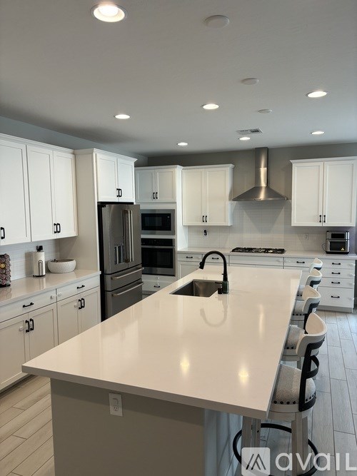 A modern kitchen with white cabinets and a large island.