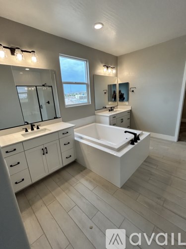 A bathroom with a tub, sink, and mirror.