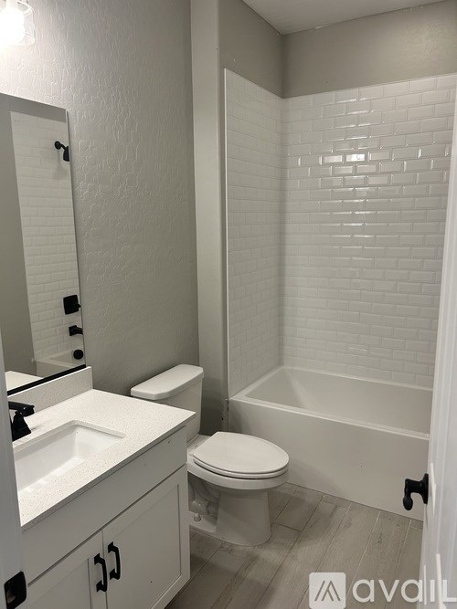 A white bathroom with a toilet, sink, and bathtub.