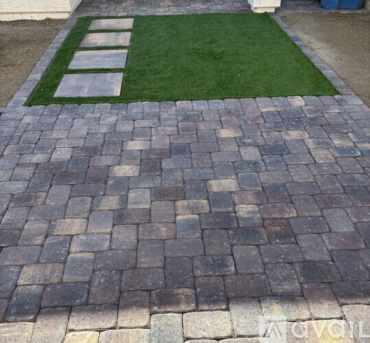 A brick walkway leads to a green lawn.