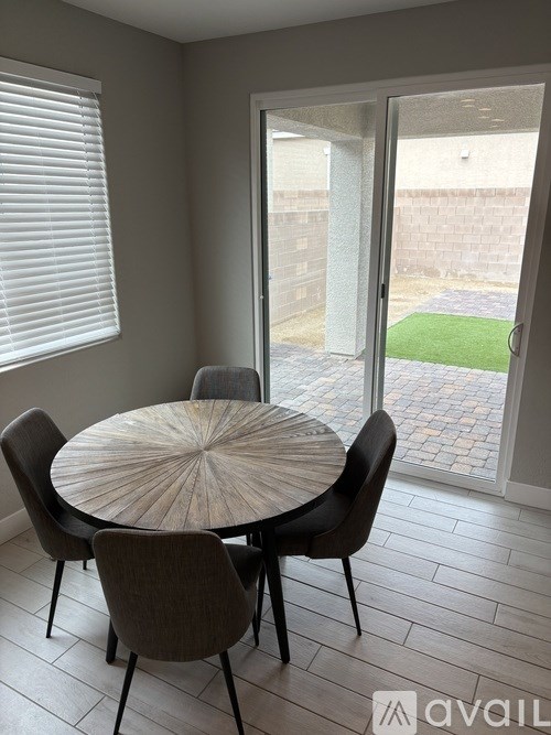 A table with chairs in front of a glass door.