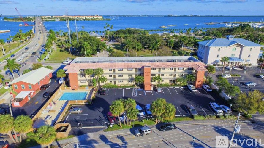 A parking lot with a building and a pool in the foreground.