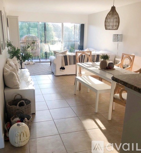 A living room with white furniture and a large window.