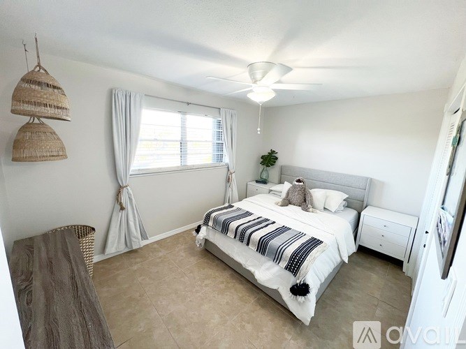 A bedroom with a large bed and a ceiling fan.