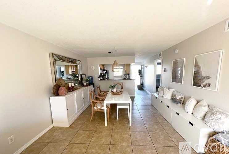 A living room with a white couch and a dining table.