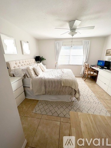 A bedroom with a large bed and a ceiling fan.