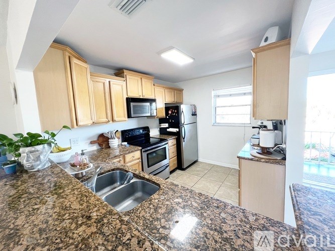A kitchen with granite countertops and wooden cabinets.