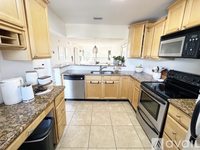 A kitchen with wooden cabinets and granite countertops.