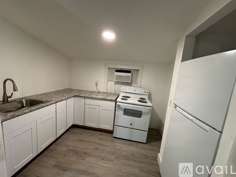 A kitchen with white appliances and cabinets.