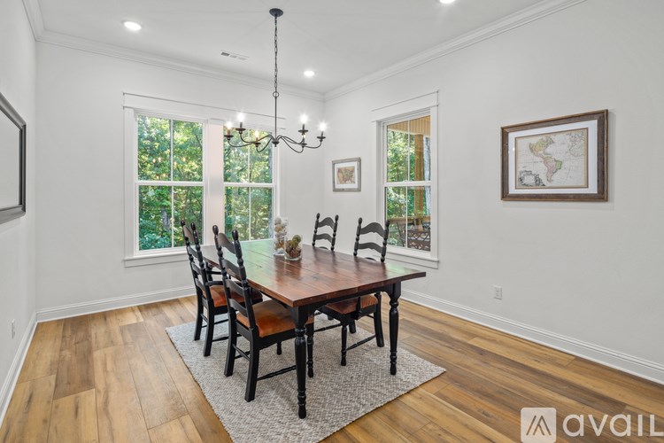 A dining room with a wooden table and chairs.