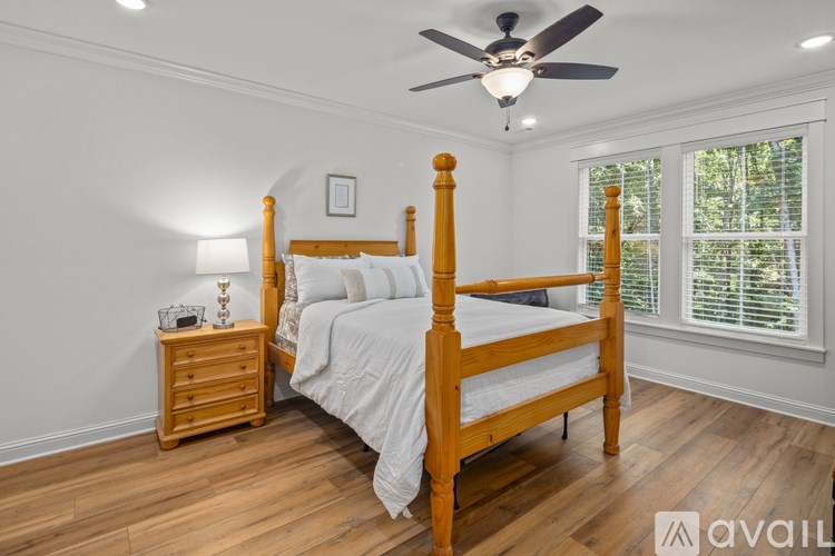 A bedroom with a bed, nightstand, and window.