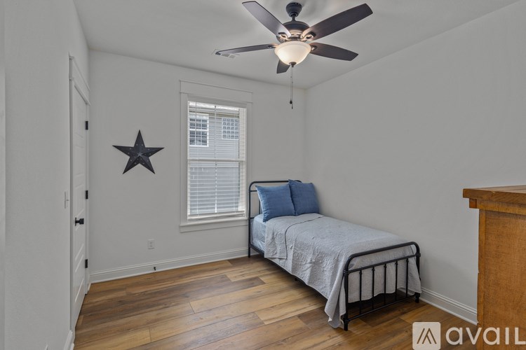 A bedroom with a bed, a ceiling fan, and a star decoration on the wall.