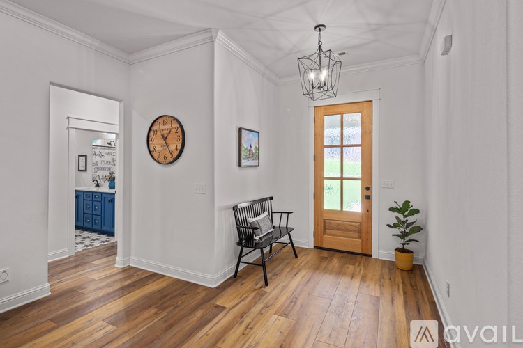 A room with a wooden floor and a large clock on the wall.