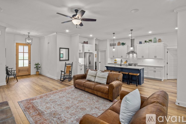 A living room with a brown couch and a rug.