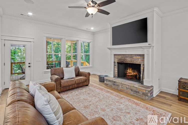 A living room with a fireplace and a flat screen TV mounted above it.