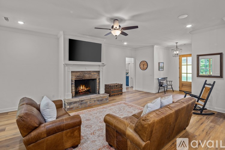 A living room with a fireplace and a television mounted above it.