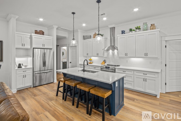 A kitchen with white cabinets and a wooden island.