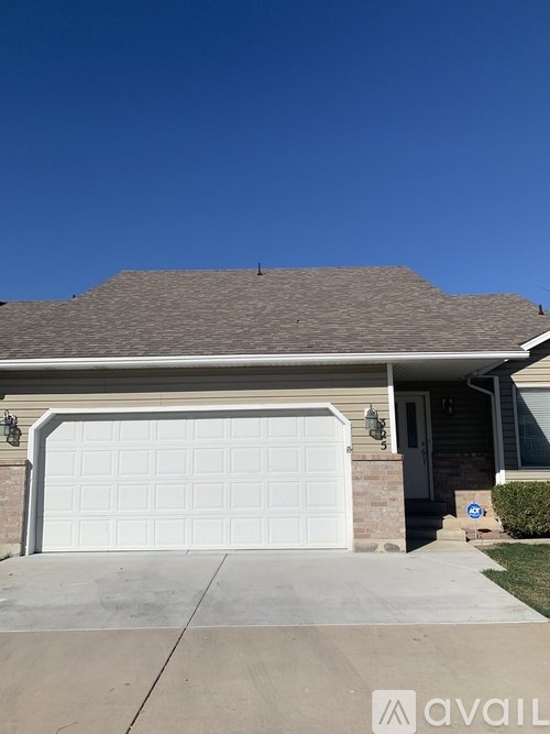 A house with a white garage door and a brown roof.