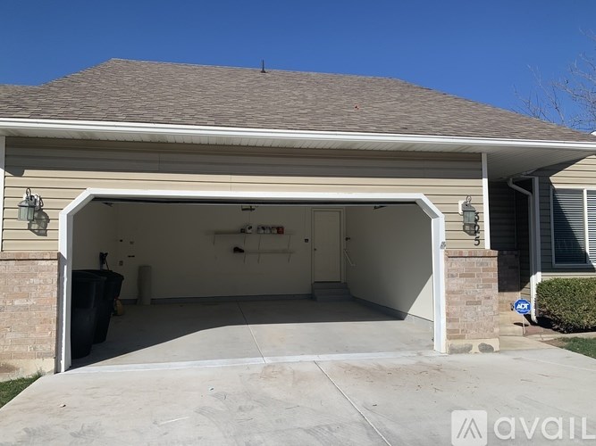 A garage with a brick wall and a white door is available for rent.