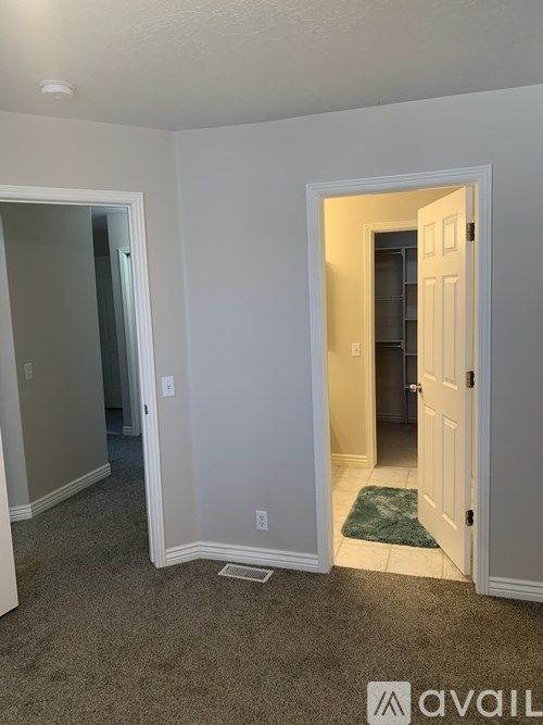 A room with a carpeted floor and a doorway leading to another room.