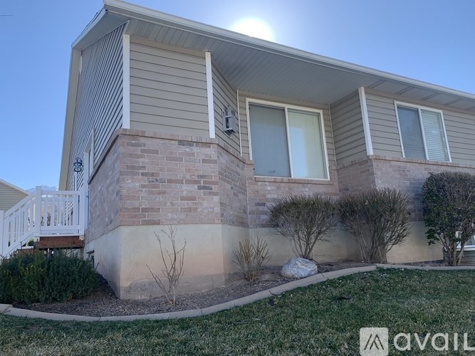 A house with a beige siding and a white porch.