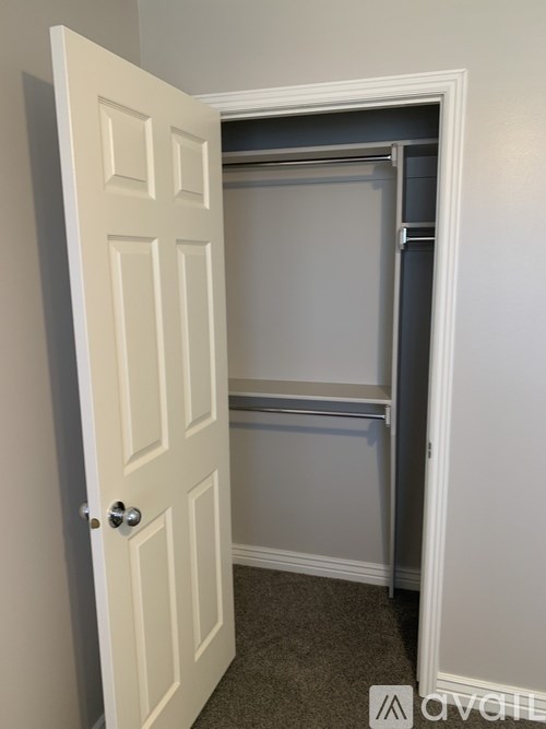 A white door is open to a small, empty room.