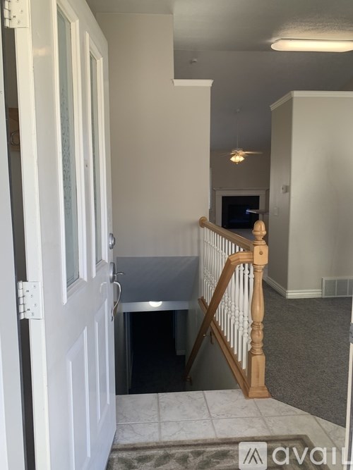 A hallway with a wooden railing and a door on the left.