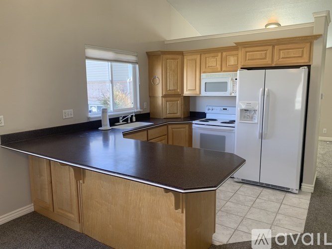 A kitchen with wooden cabinets and a black countertop.