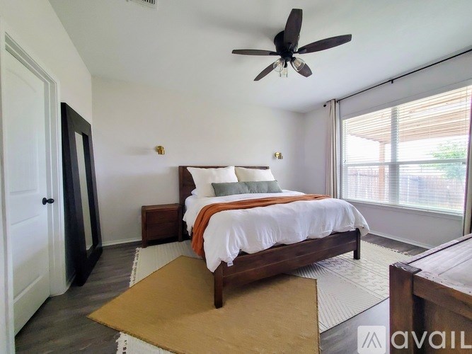 A bedroom with a bed, a ceiling fan, and a rug.