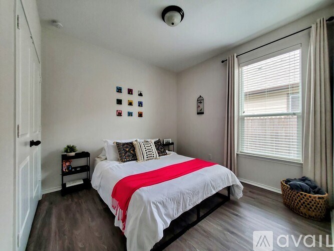 A bedroom with a bed, nightstand, and window.