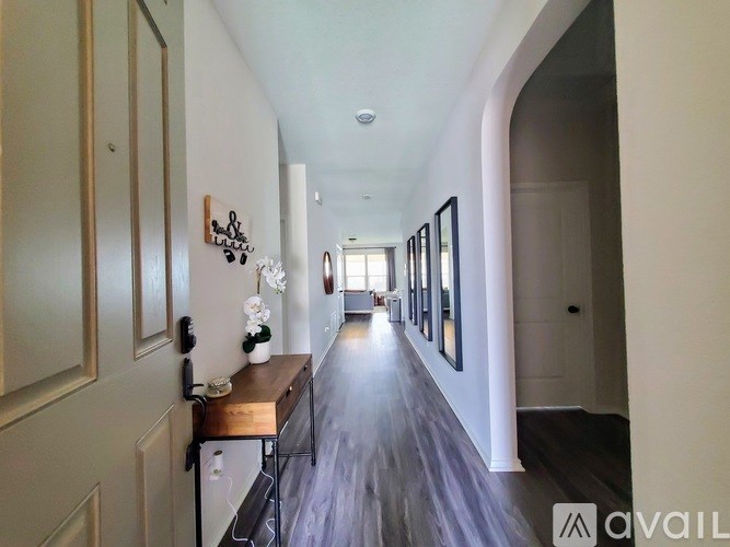 A long hallway with a wooden floor and white walls.