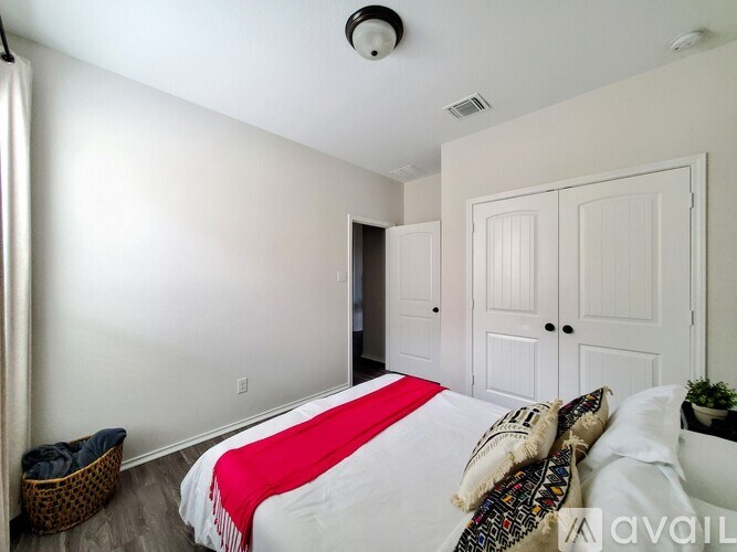 A bedroom with a bed, pillows, and a basket on the floor.
