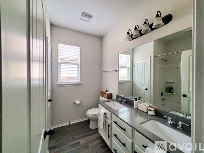 A bathroom with a toilet, sink, and mirror.