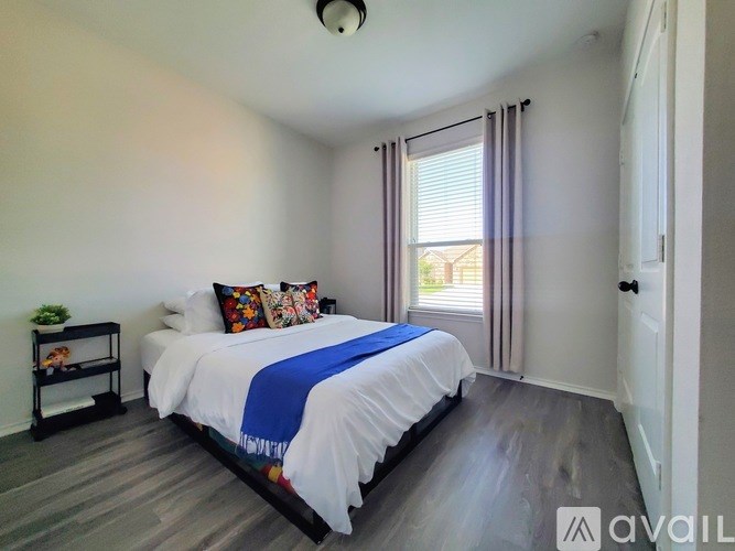 A bedroom with a bed, pillows, and a nightstand.