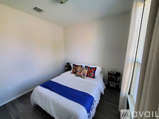 A bedroom with a bed, pillows, and a nightstand.