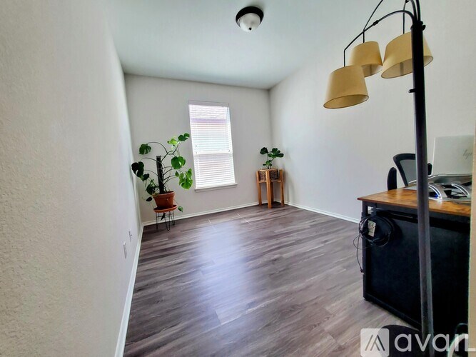 A room with wooden flooring and a ceiling light.