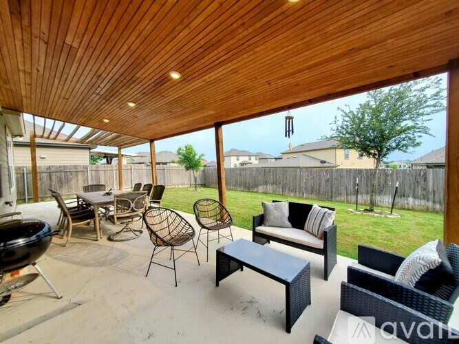 A patio with a wooden ceiling and furniture.