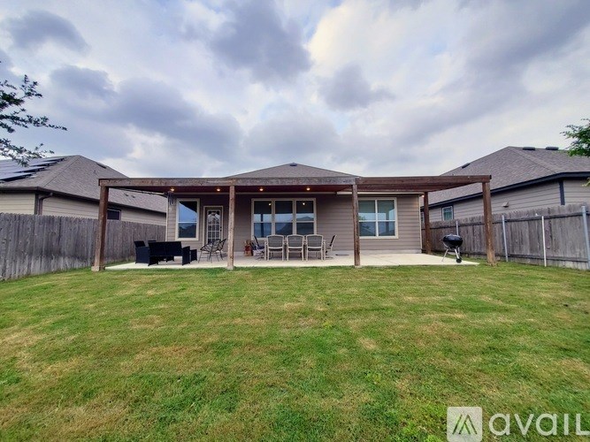 A backyard with a patio and a fence.