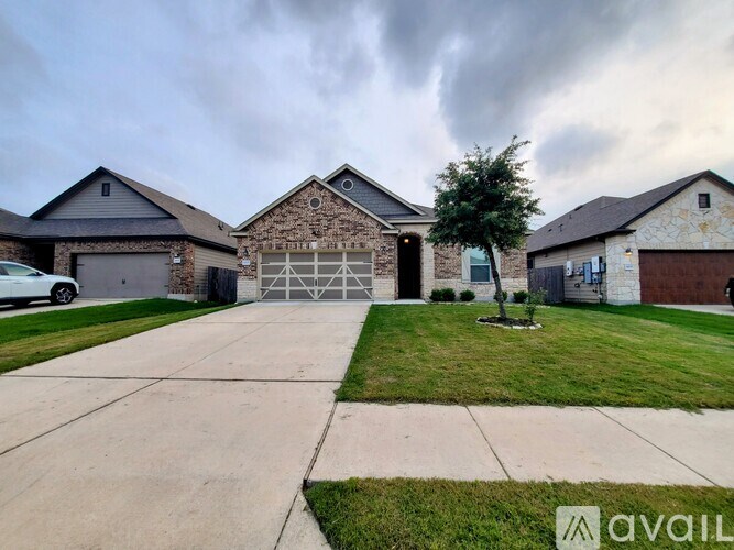 A house with a driveway and a tree in front of it.