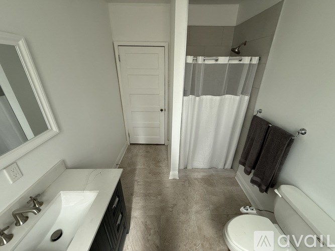 A bathroom with a white sink, toilet, and bathtub.