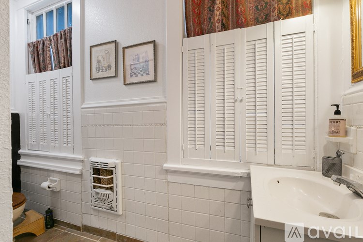 A bathroom with white walls and a white sink.