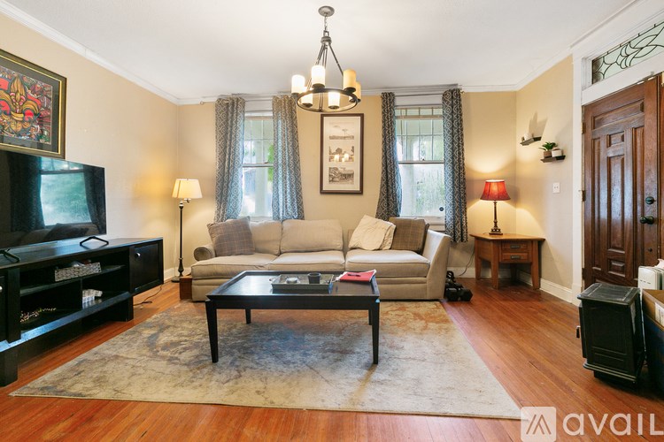A living room with a couch, a coffee table, and a television.