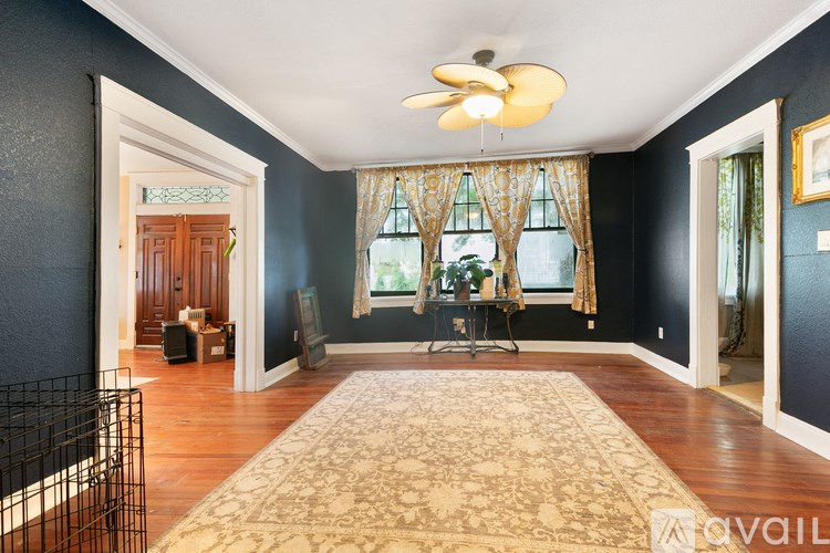 A room with a rug on the floor and a fan on the ceiling.