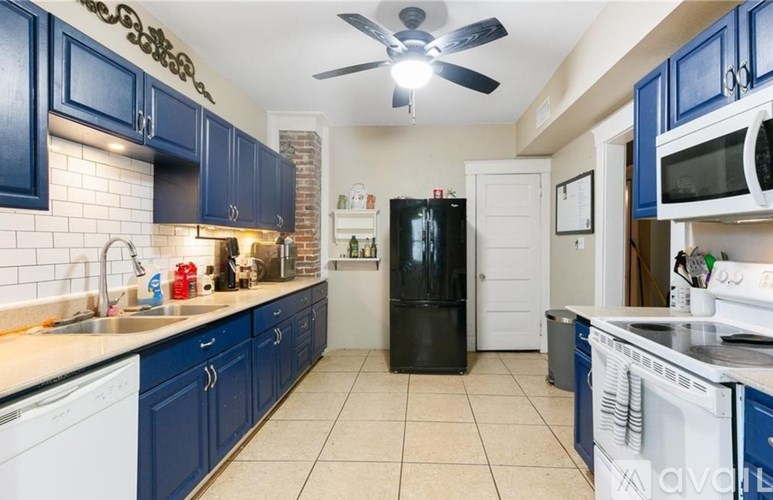 A kitchen with blue cabinets and white appliances.